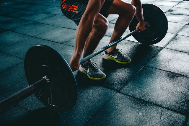 Image shows a person lifting heavy weights